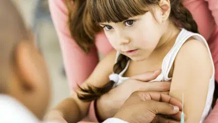 Little girl getting a needle at the doctor's office