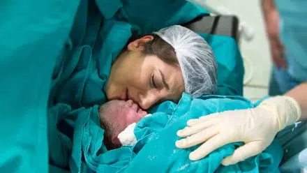 mom meeting baby for the first time after a C-section
