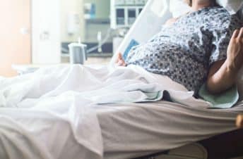 Pregnant woman in hospital bed giving birth