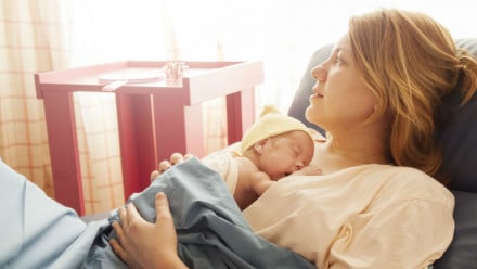 woman holding her newborn baby in hospital