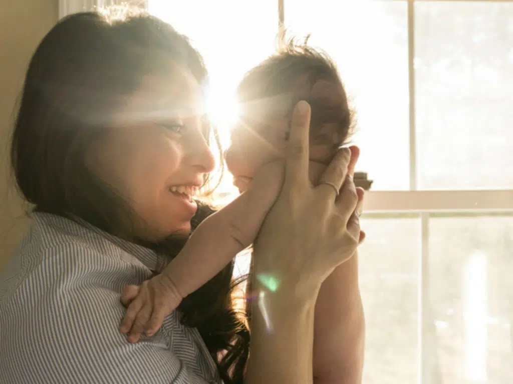 A woman holds a newborn to her face