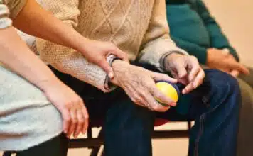 les mains d'un homme âgé et d'une soignante