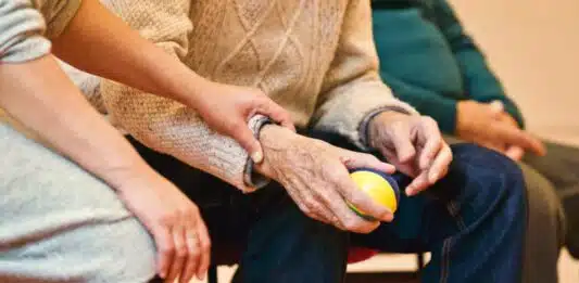 les mains d'un homme âgé et d'une soignante