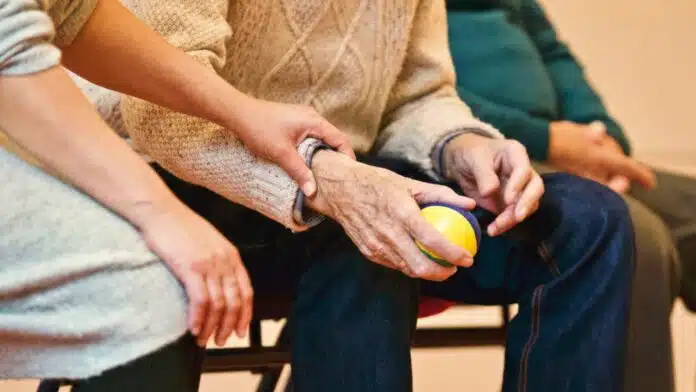 les mains d'un homme âgé et d'une soignante