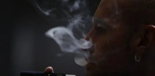 Un homme fumant une cigarette IQOS