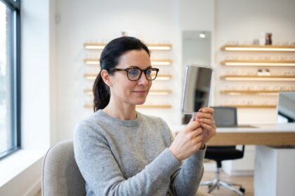 Femme essayant des lunettes chez un opticien professionnel lors d'une consultation optique